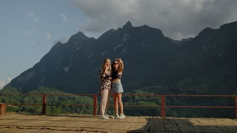 two women taking a selfie in a mountainous landscape