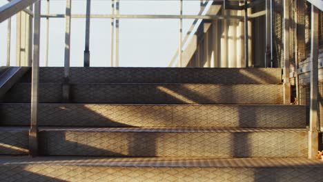 man walking up metal stairs