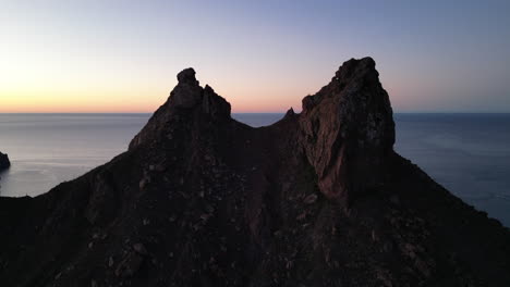 take a mountain aerial view with two peaks and sea in the background