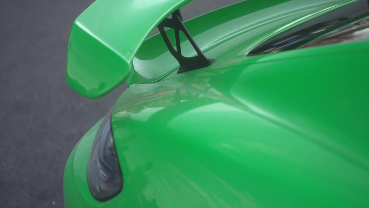 Detailaufnahme des Heckflügels eines grünen modernen Sportwagens in 4K