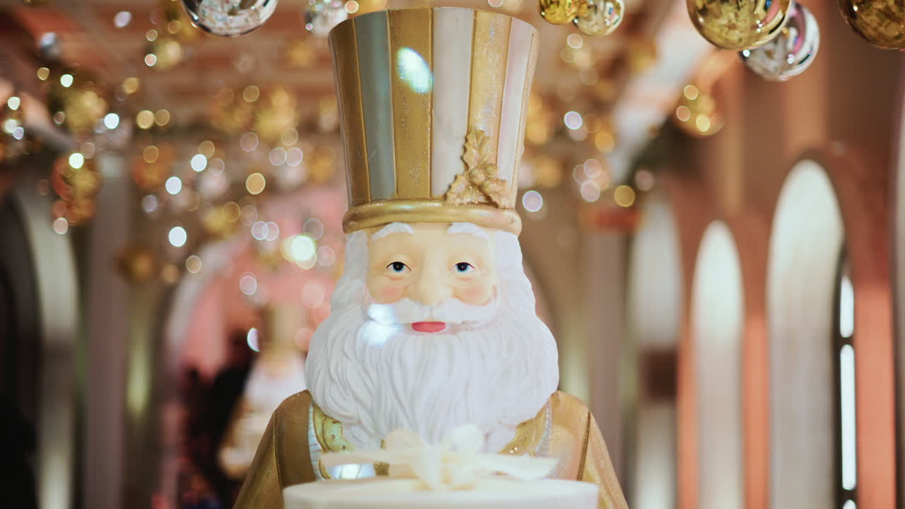 Close up of a Santa Claus figure inside a festive Christmas installation with warm lights and ornaments
