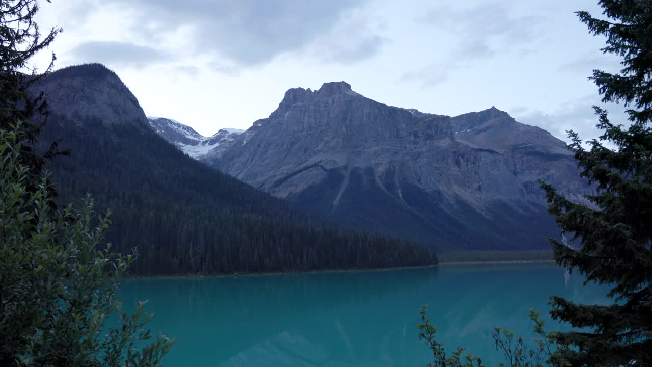 Tranquil, crystal clear Emerald Lake at dusk, peacefully framed between trees