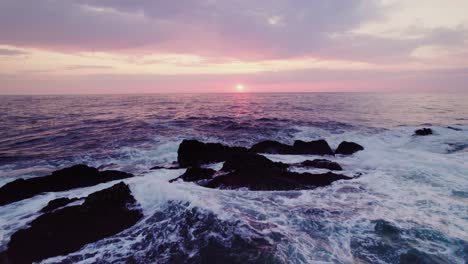 sunset over the ocean with rocky coastline