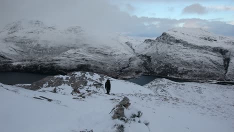 hiker climbing snowy mountain, torridon, scotland