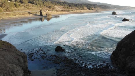 drone vuela entre pilas de mar en la playa