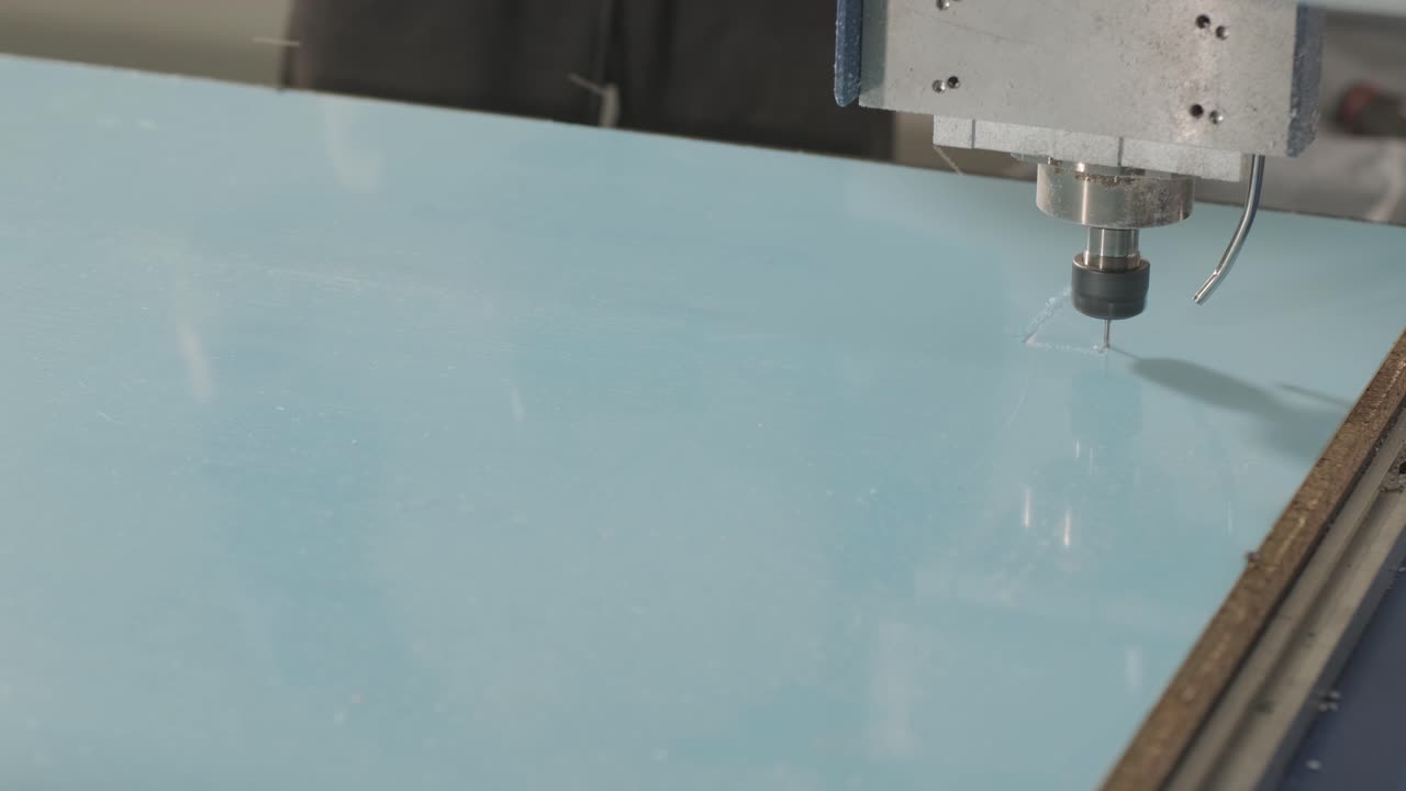 máquina de corte cnc en el trabajo, corte de hojas de plástico acrílico. producción de carteles publicitarios