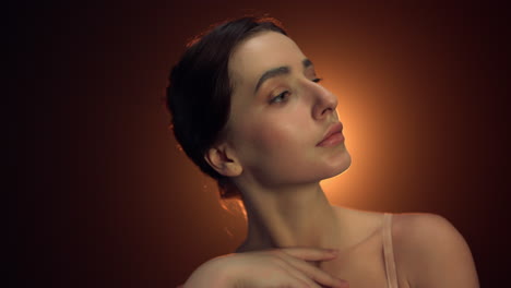 portrait woman dancer looking camera in studio. beautiful woman touching neck.