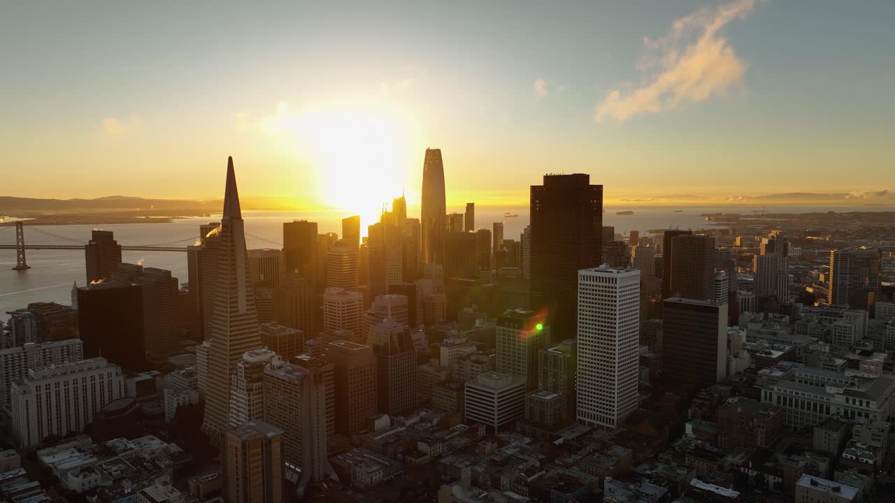 la brillante luz del sol se proyecta sobre la bahía de san francisco y el distrito financiero al amanecer, vista aérea