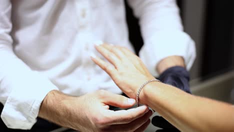 close up of person putting bracelet on wrist