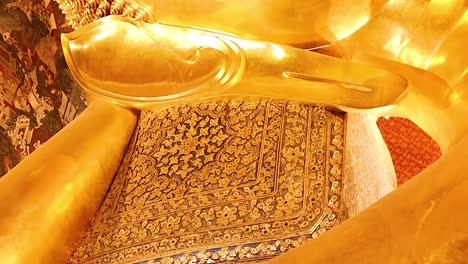 close-up views of the golden reclining buddha's serene face and intricately detailed feet.