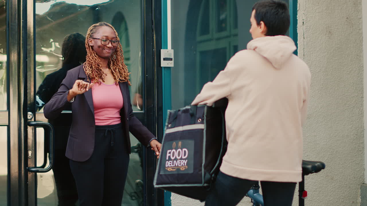 A businesswoman receiving a food delivery from a courier