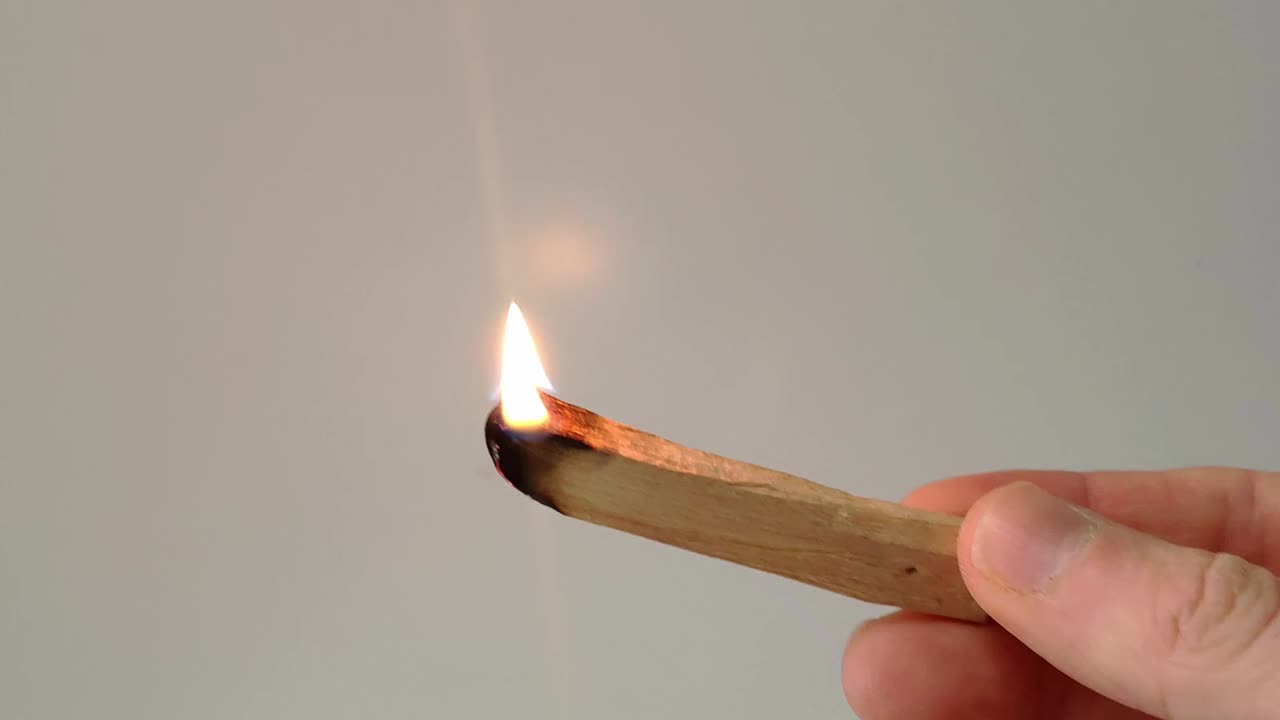 un palo de palo santo se enciende con un encendedor