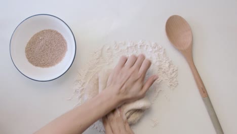 top view of a hands in a minimal white table kneading dough