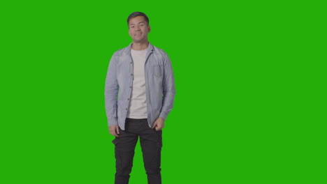 studio shot of casually dressed young man giving thumbs up gesture against green screen 4