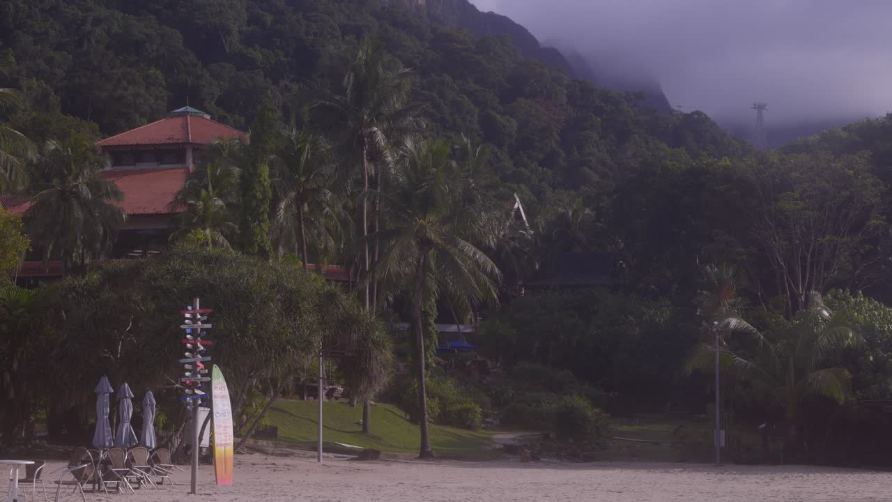 vista panorámica del edificio frente a la playa escondido por los árboles en el complejo berjaya langkawi