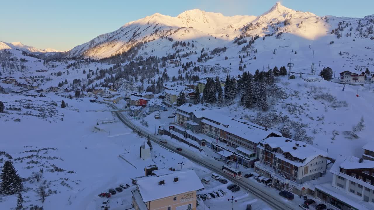 Estación de Obertauern cubierta de nieve vista desde arriba, autobús lleno de turistas en temporada alta