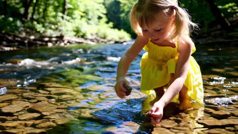 young girl playing in a shallow rocky stream