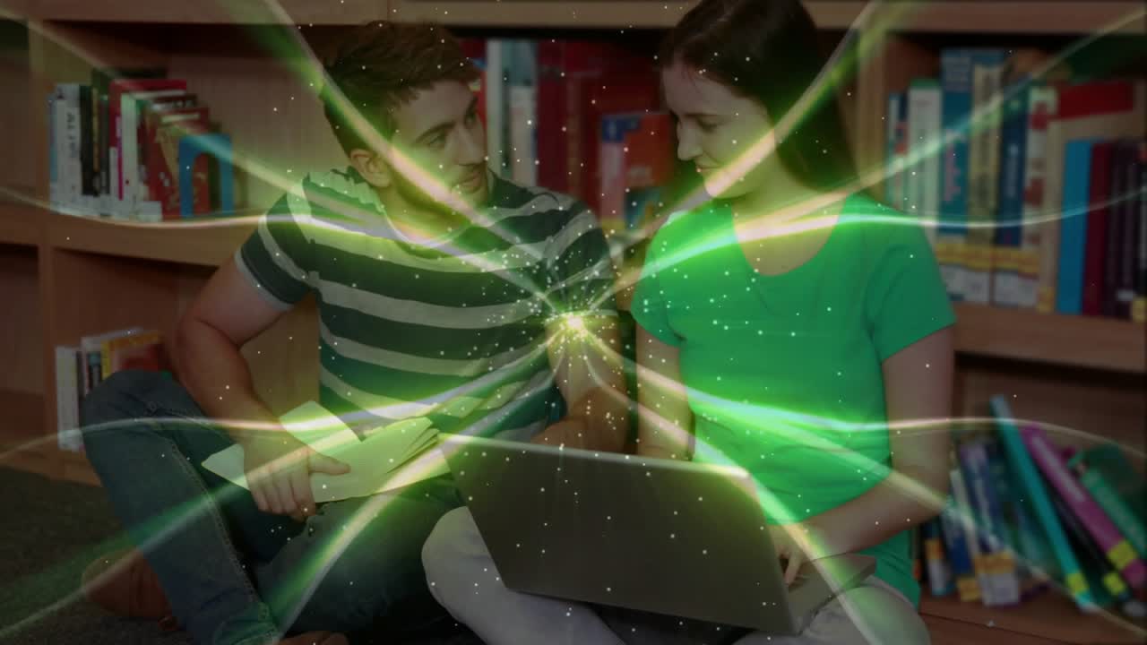Man and woman positioning laptop on lap, green study visualization beams swirling over bookshelf