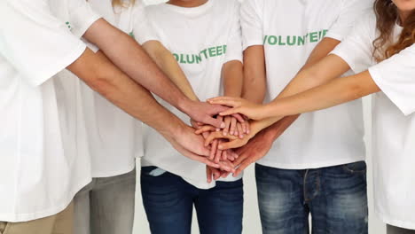 team of volunteers putting hands together