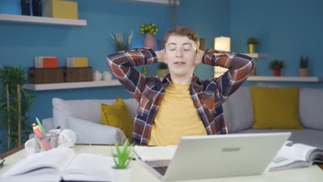 student relaxes after completing homework on laptop.