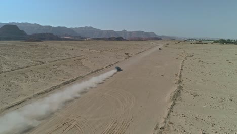vista aérea de un automóvil deportivo rápido conduciendo por un camino desértico remoto