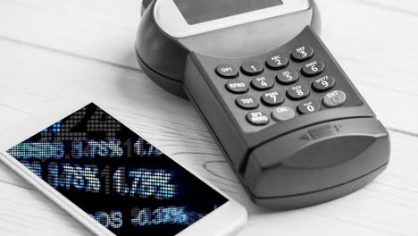 animación del procesamiento de datos financieros en el teléfono inteligente junto a la terminal de tarjeta de crédito