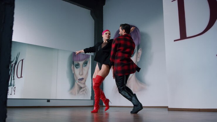 Dance couple practicing professional studio. Attractive dancers dancing indoors