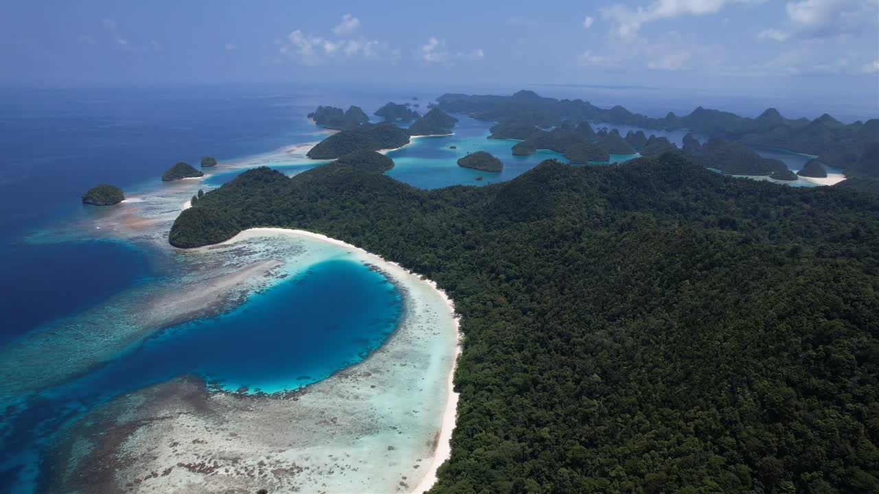 high altitude stunning view, sliding left on many islands, white sandy beaches, lush green flora, coral reefs in Raja Ampat, Wayag, Indonesia