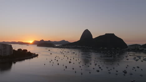 imágenes aéreas a la luz de la madrugada girando alrededor de la bahía de botafogo y río de janeiro, brasil con la montaña sugarloaf en el fondo