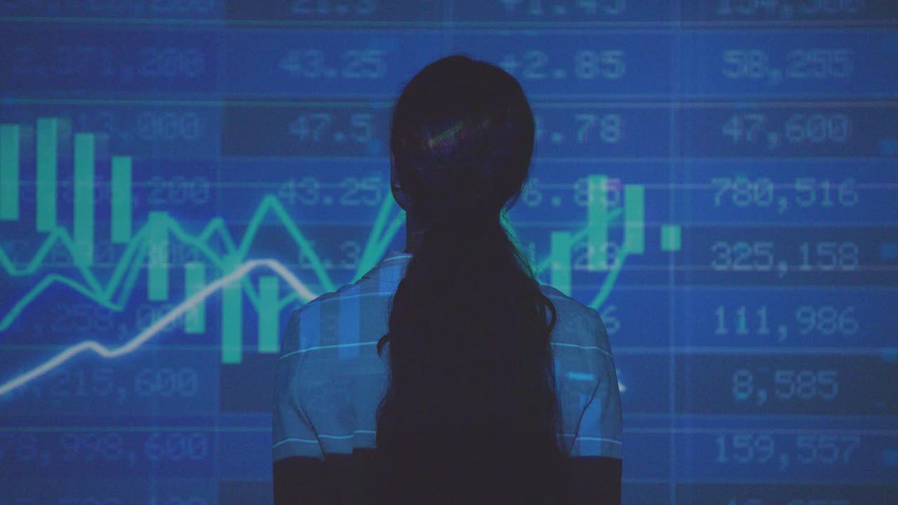 mujer visitando una exposición de arte inmersiva con proyección de datos financieros con gráficos y precios de las acciones 12