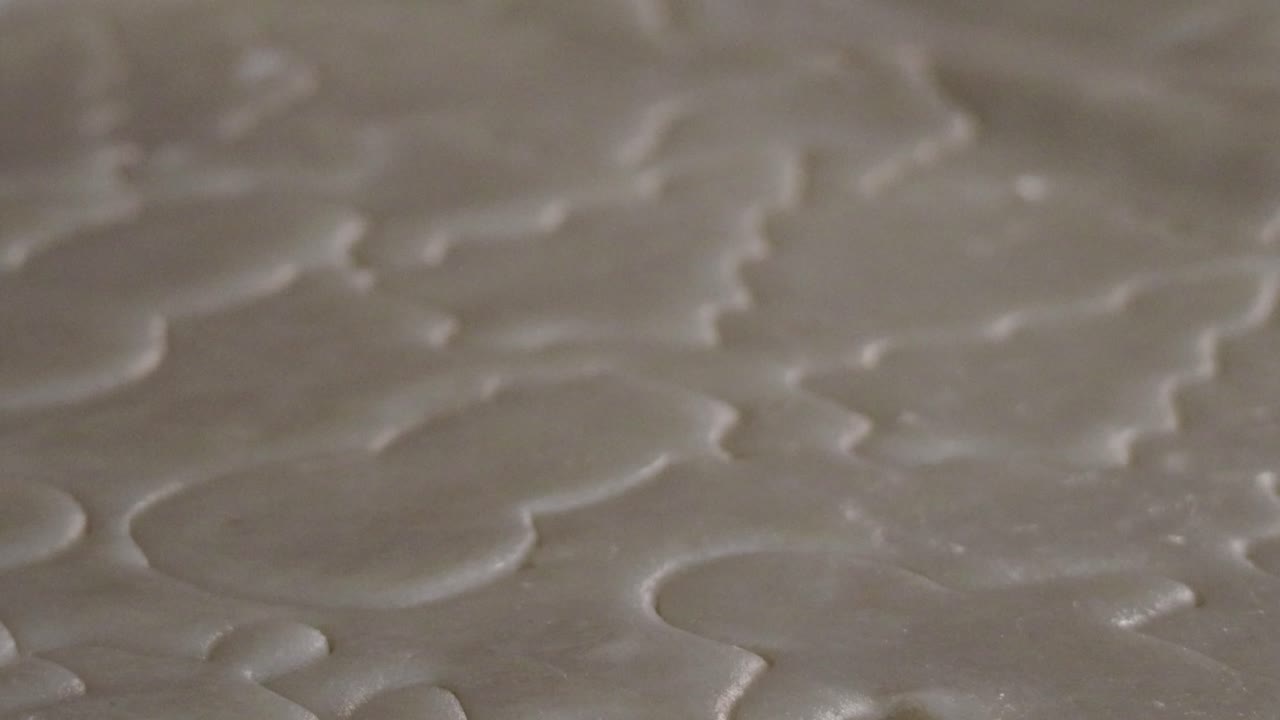 Snowmen, Christmas trees, and other holiday shapes are carved into cookie dough by cookie cutters before being baked