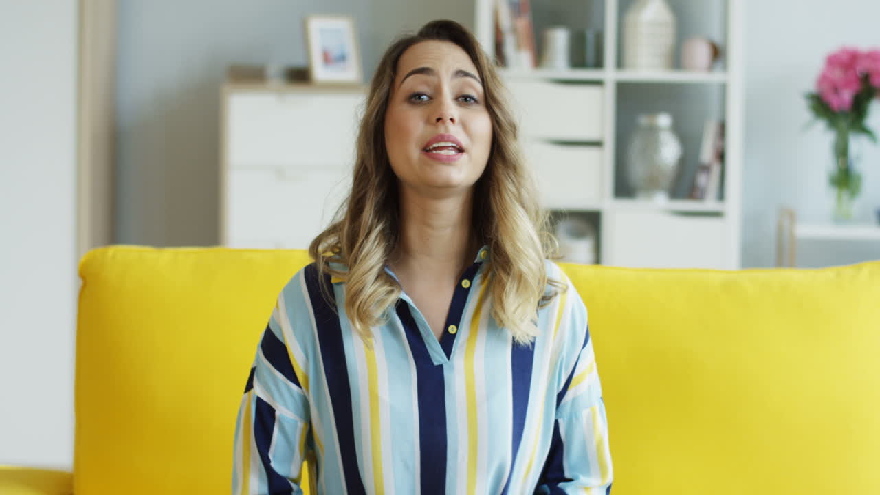 Smiling Pretty Young Woman Recording Her Video Blog While Sitting On The Couch At Home