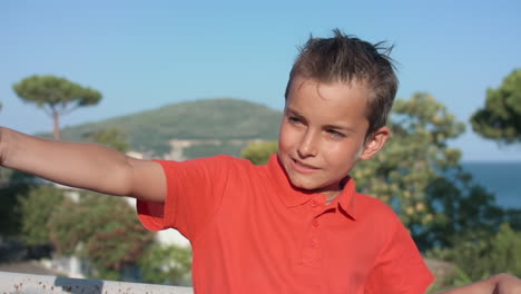 cheerful boy speaking by mobile phone outside. guy enjoying holiday outdoor.