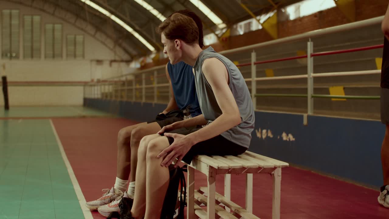 Giocatori di basket che si allenano e riposano in una palestra.