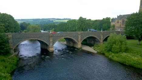 aerial drone shot flying towards the tweed bridge over the river tweed in the town of peebles in the scottish borders