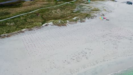 vista de la órbita aérea sobre la costa de noruega filas frente al mar de banderas de países nórdicos en la playa de arena