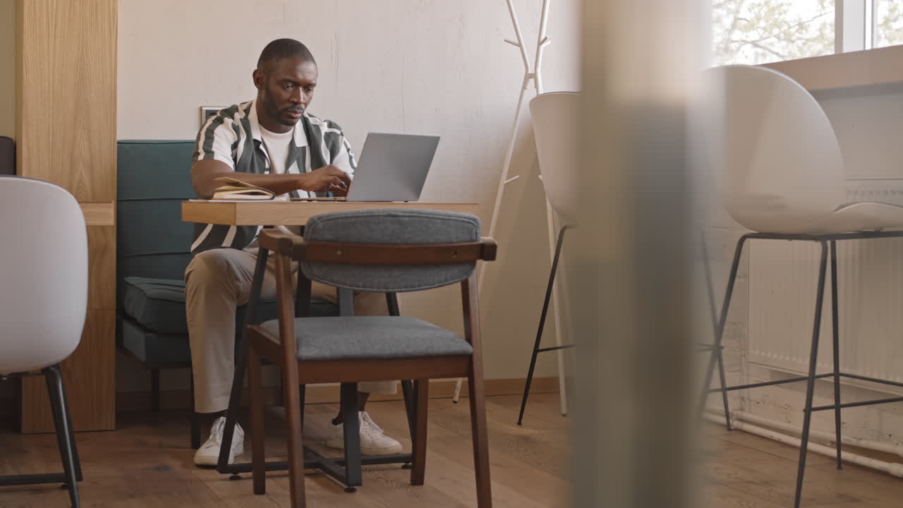 Afro American Freelancer Working on Laptop in Cafe