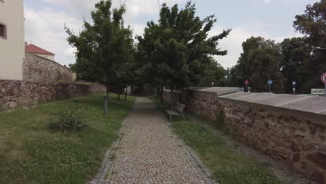 Caminando-Por-Un-Sendero-Con-Una-Antigua-Muralla-A-Ambos-Lados