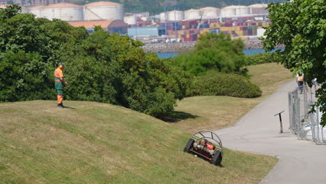 gijon, spain - august 3, 2025: close-up of the agria 9600 remote-controlled tracked mower operating on a grassy slope. the equipment is used for landscaping maintenance in public areas, especially on difficult-to-access terrain