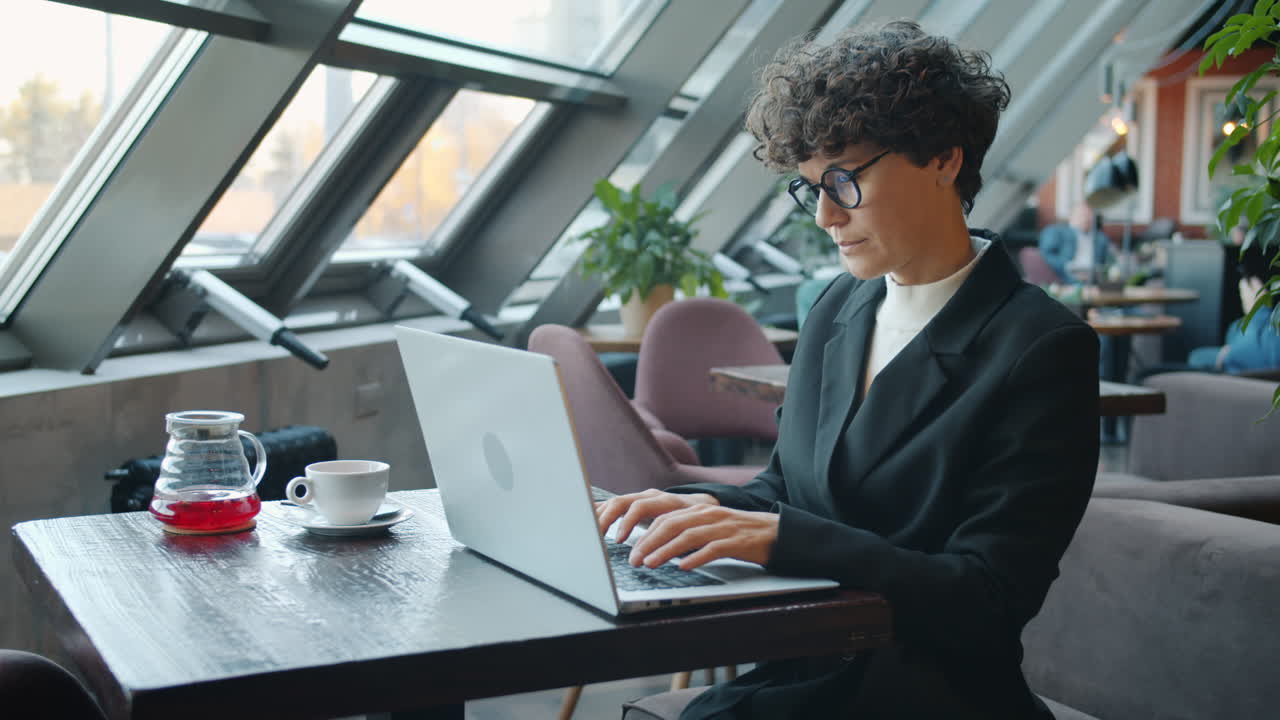 Woman working on laptop in a modern cafe