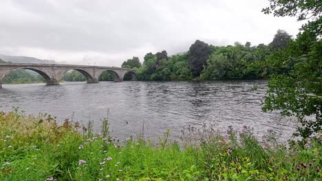 a serene river view with a historic bridge