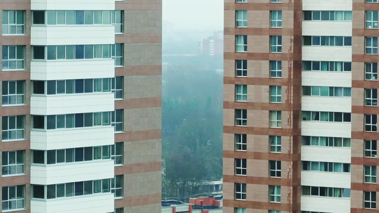 Long lens captures Riga skyline framed between high-rises with misty urban depth