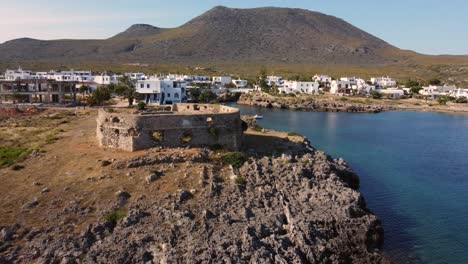 drone footage of kythira greek island beach, with white village houses in the background