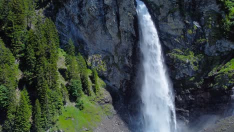 Drone-orbit-cascading-white-water-cutting-through-grey-rocks-in-Swiss-alps