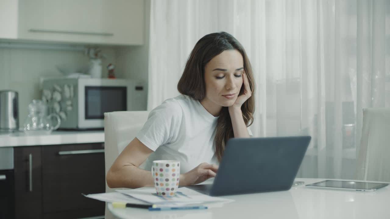 mujer cansada trabajando en una computadora portátil en el lugar de trabajo de casa. persona frustrada