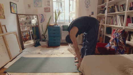 young man practicing vinyasa yoga at home