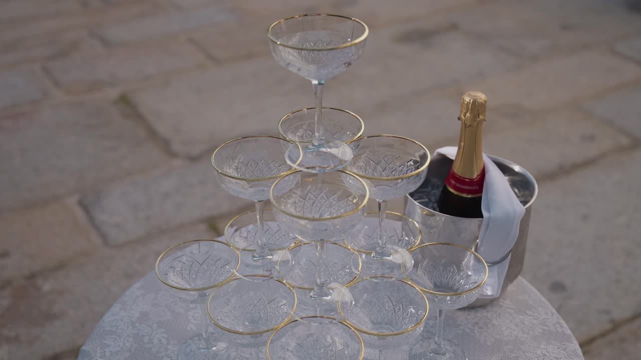 차가운 병 옆에 탑처럼 쌓인 크리스탈 샴페인 잔