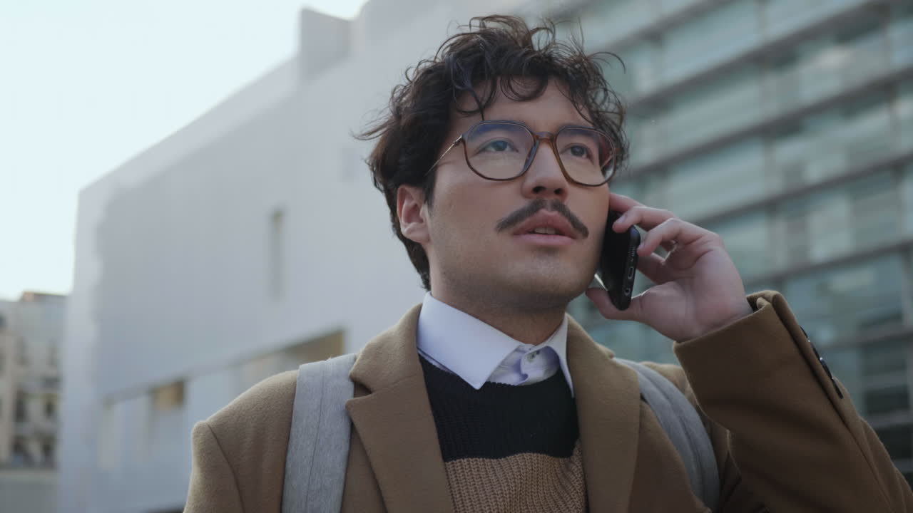 사업가 가 야외 에서 전화 대화 를 하고 있다