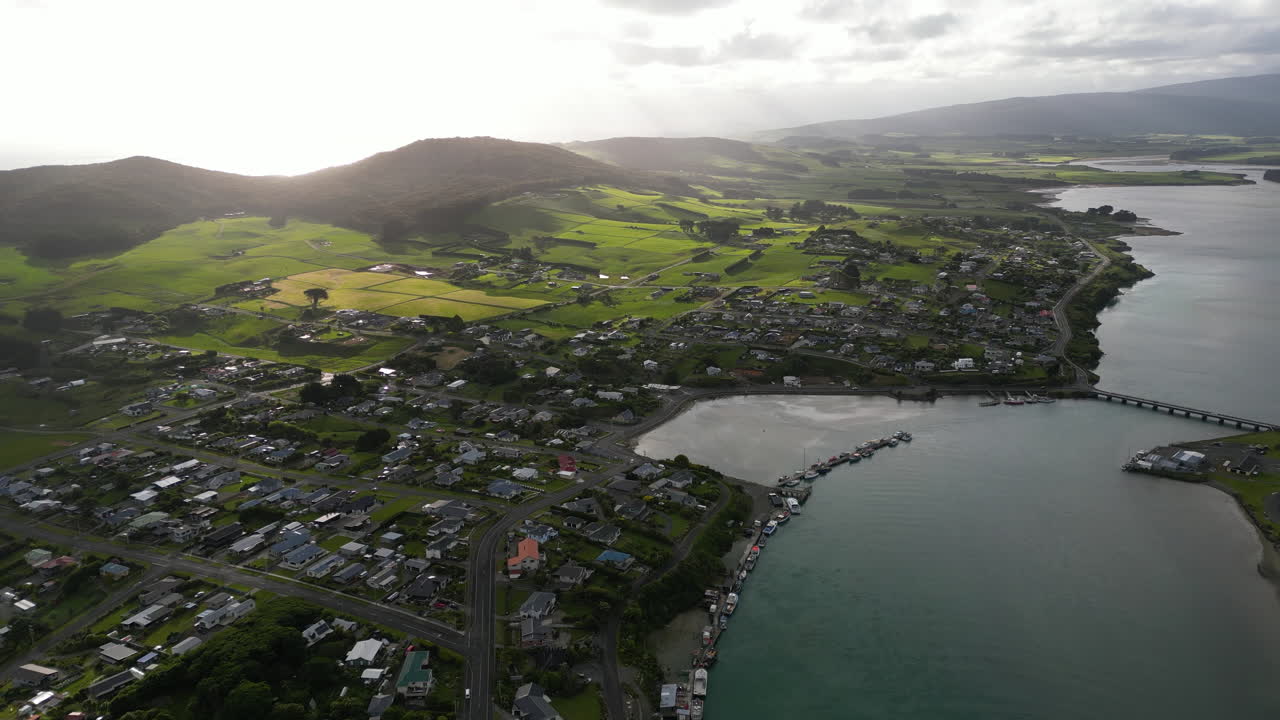 поселок ривертон в пасмурный день с горным пейзажем на горизонте на юго-восточном берегу устья реки джейкобс, съемка с воздуха