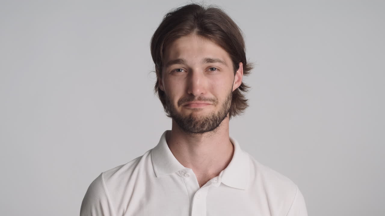 hombre caucásico frente a la cámara sobre un fondo gris.